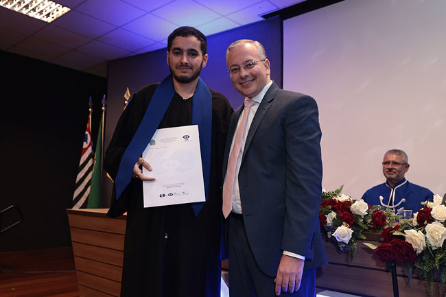 Felipe Meme de Souza, representante do Conselho Regional de Administração de São Paulo (CRA-SP), entregando prêmio ao formando Victor Silva Pereira.