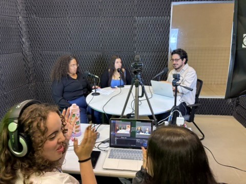 Gravação ao vivo de um episódio: estudantes entrevistados à mesa, operação de câmera e acompanhamento técnico.