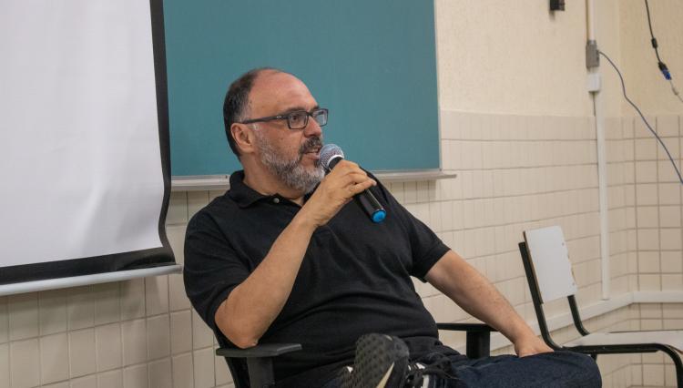 Homem palestrante com microfone em sala de aula