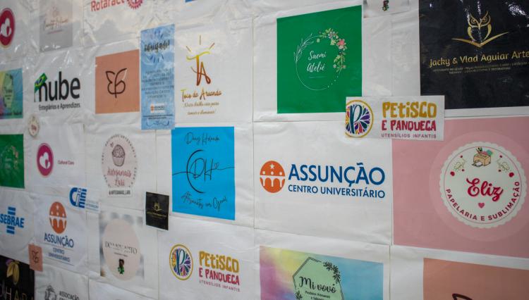 Painel com logo do Assunção e de expositores da feira